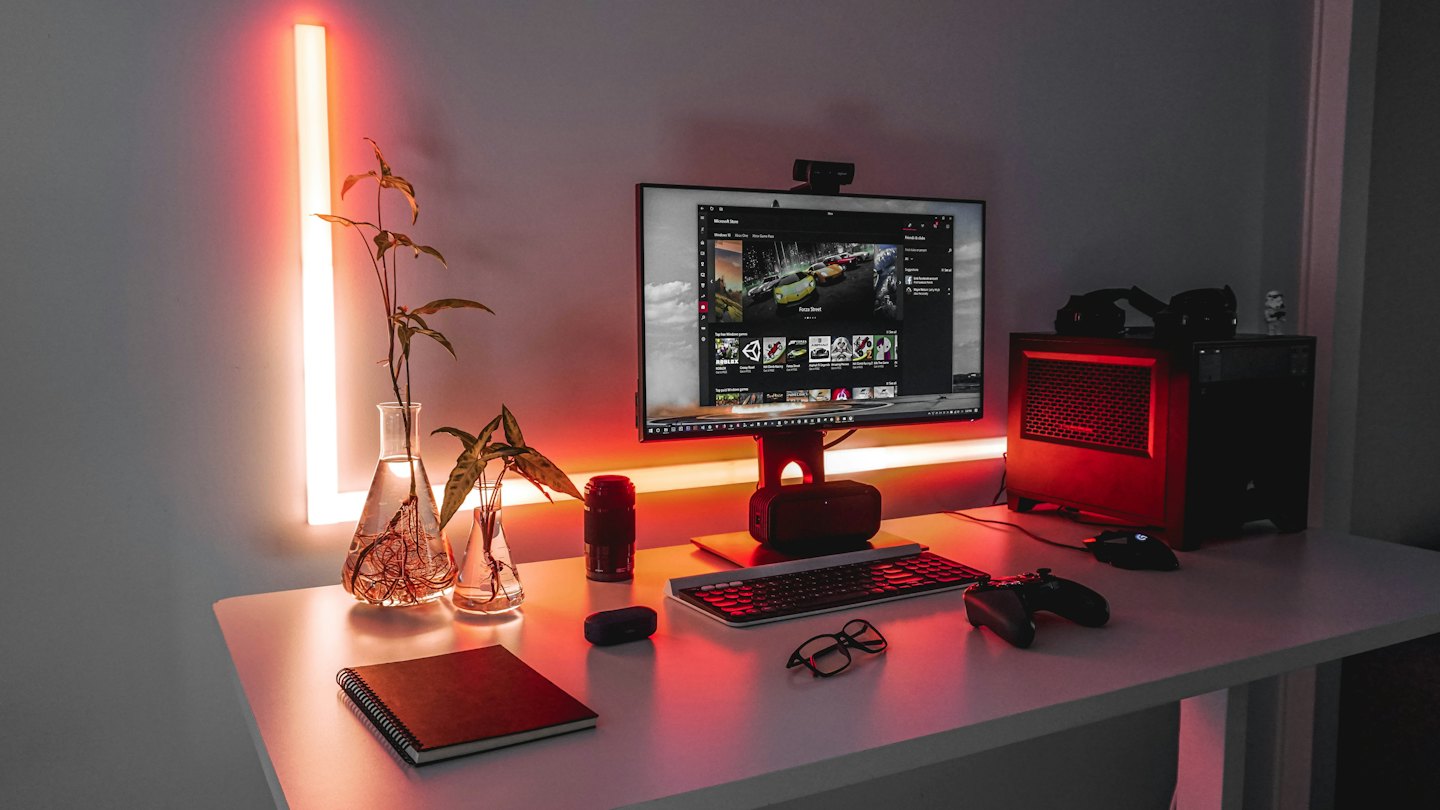 Gaming desk with computer, keyboard, mouse, and headset.