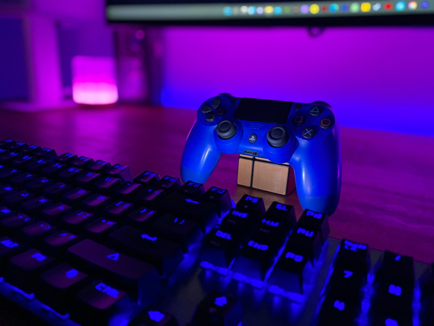 Blue gaming controller rests on a small gold cube.