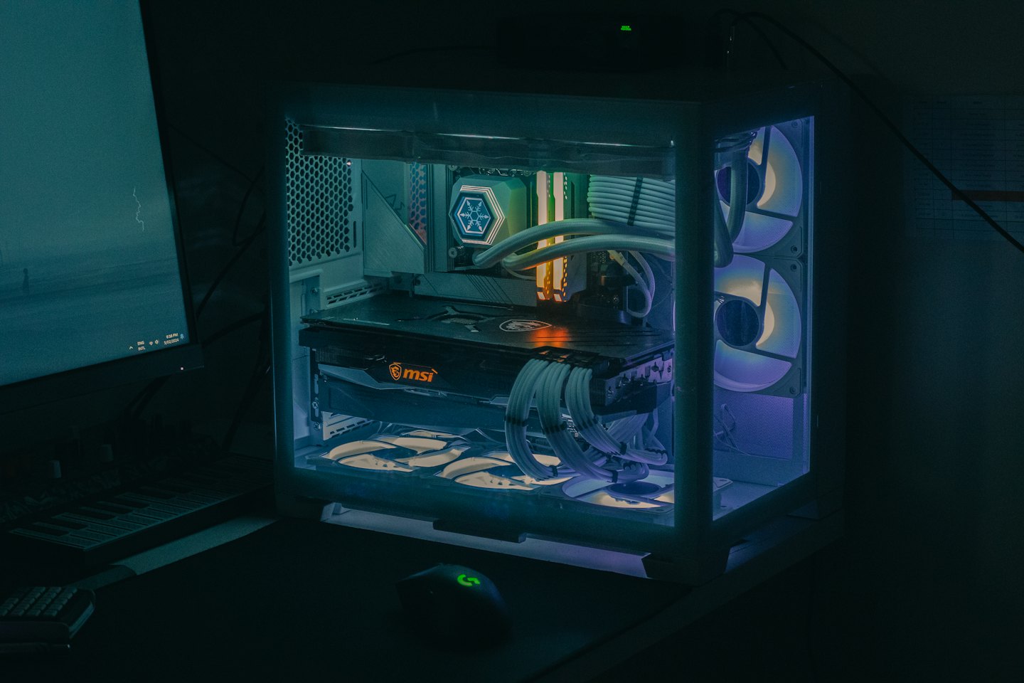 A glowing gaming desktop computer sits on a desk.